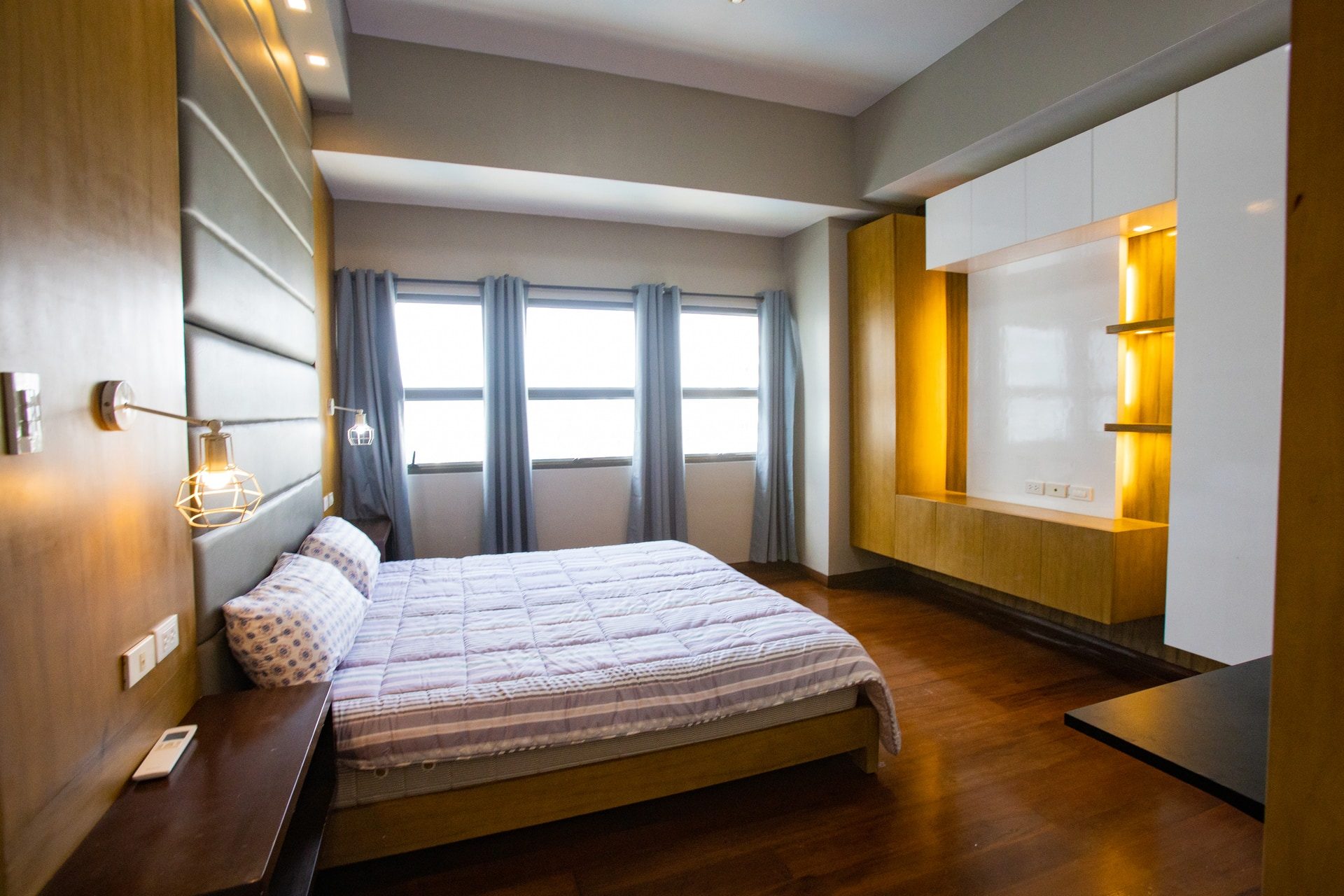 Apartment 1809 bedroom with wood-toned flooring, a double bed and illuminated built-in cabinetry