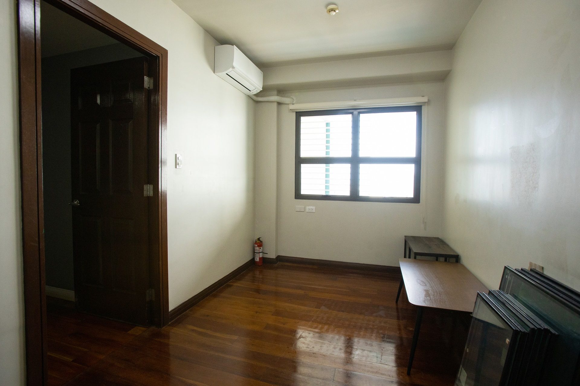 Apartment 1809 second room with wood-toned flooring, a window and wall-mounted air conditioning